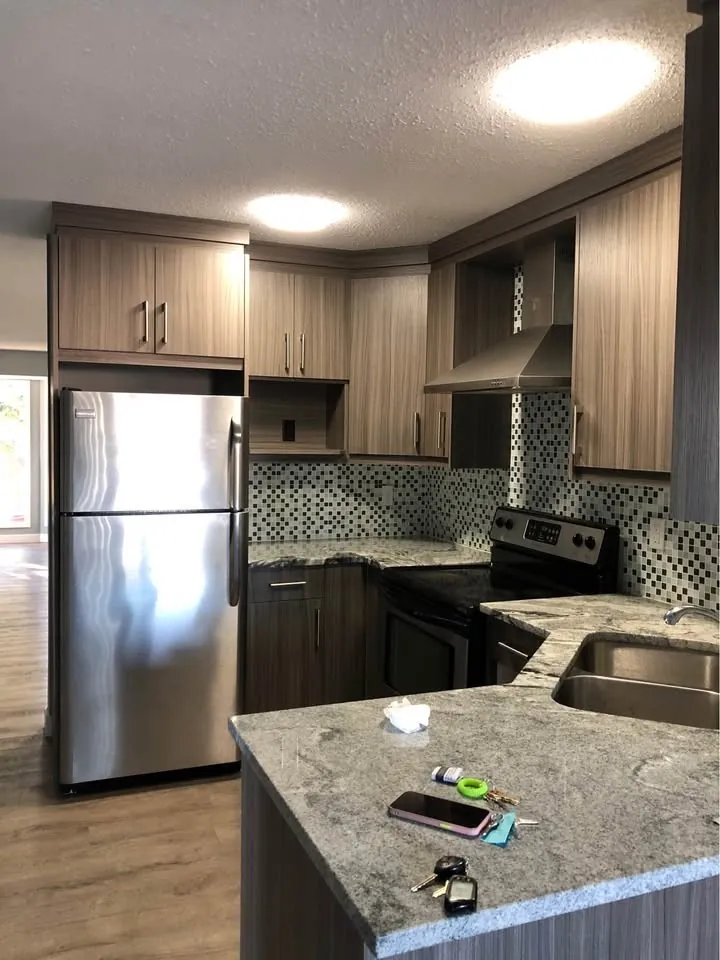 Renovated kitchen with stainless appliances in the Falconridge Place upstairs suite